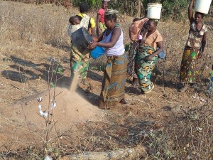 Women contribute sand to the water Borehole pump